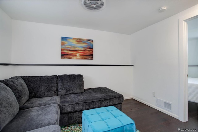 living area with baseboards, visible vents, and wood finished floors