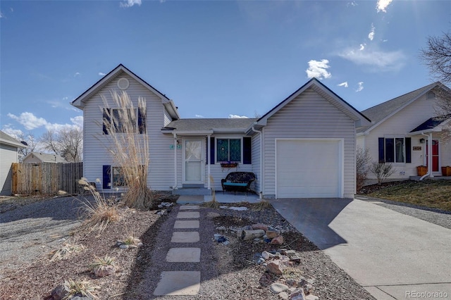 view of front of house with driveway, an attached garage, and fence