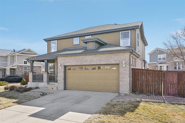 view of front facade with fence, a porch, a shingled roof, concrete driveway, and brick siding