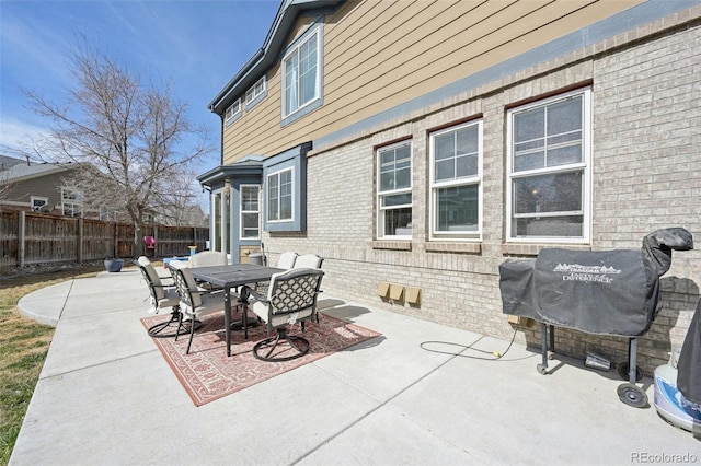 view of patio / terrace with outdoor dining space, a grill, and fence