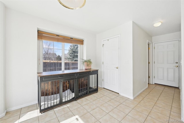 empty room featuring light tile patterned floors and baseboards