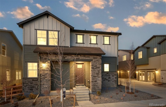 view of front of property with stone siding, board and batten siding, and concrete driveway