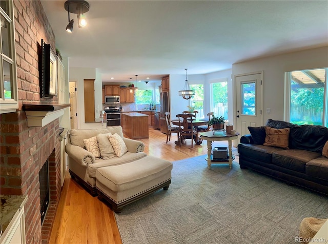 15674 Greenstone Cir, Parker, CO 80134 - living area featuring light wood-style floors and a brick fireplace
