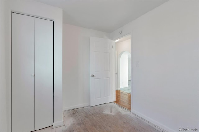 unfurnished bedroom with a closet and light hardwood / wood-style floors