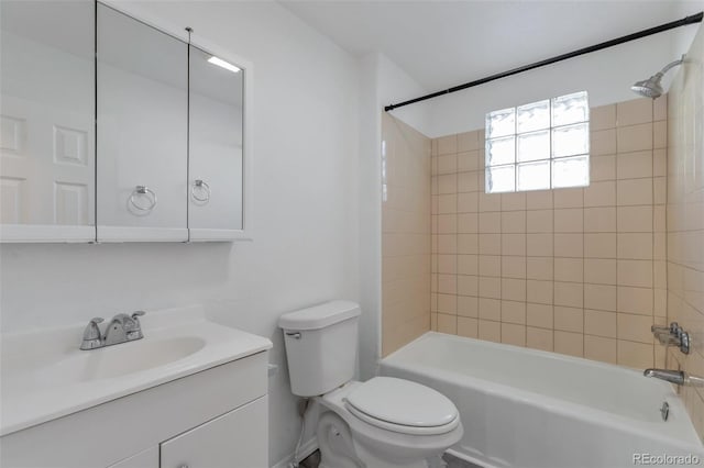 full bathroom featuring tiled shower / bath, vanity, and toilet