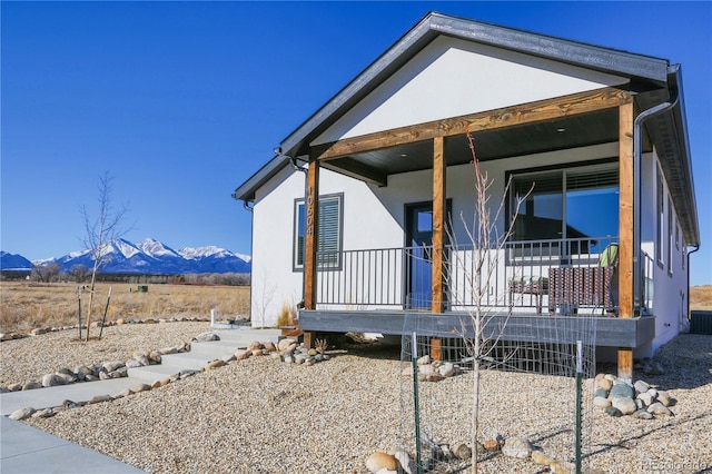 view of side of home featuring a porch and a mountain view