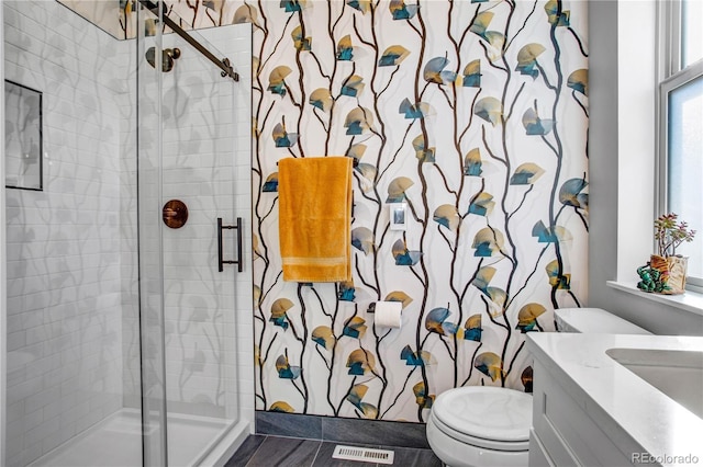 bathroom featuring vanity, an enclosed shower, and toilet