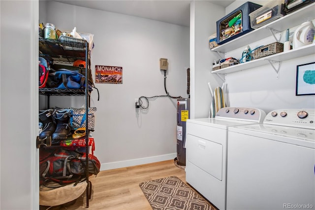 clothes washing area with independent washer and dryer, electric water heater, and light hardwood / wood-style flooring