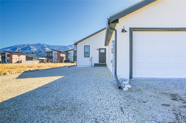 view of side of home featuring a garage and a mountain view