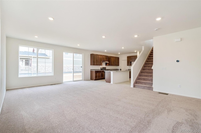 20630 E 58th Ave, Aurora, CO 80019 - unfurnished living room featuring light carpet, recessed lighting, stairs, and baseboards