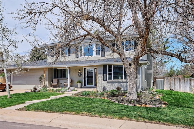 traditional-style house with fence, an attached garage, brick siding, a porch, and a front yard