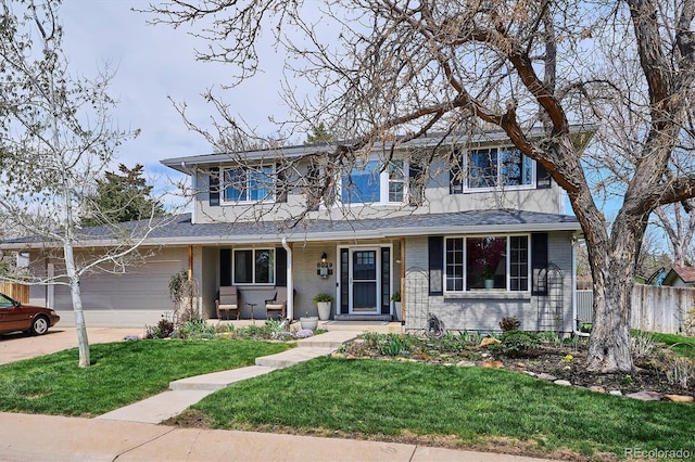 traditional home with fence, a front yard, brick siding, concrete driveway, and an attached garage
