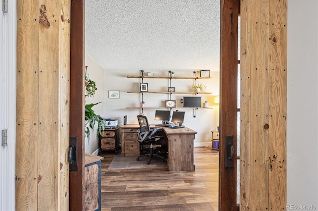 home office featuring a textured ceiling and wood finished floors