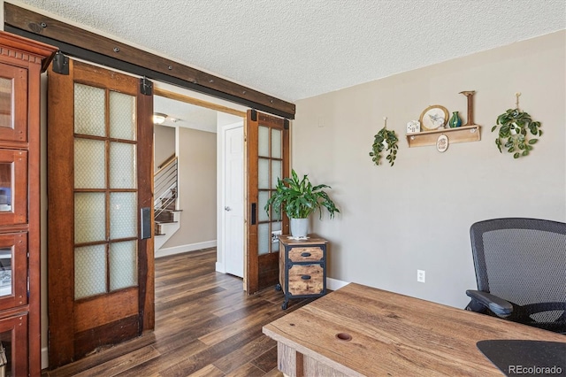 office featuring a barn door, a textured ceiling, and dark wood-style floors