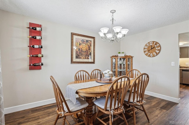 dining room with an inviting chandelier, a textured ceiling, baseboards, and dark wood-style floors