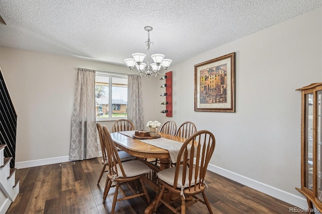 dining room with baseboards, a textured ceiling, dark wood-style flooring, and a chandelier