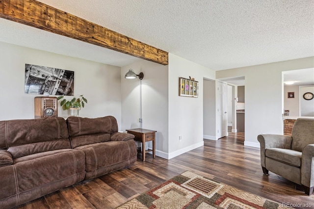 living area with baseboards, beamed ceiling, dark wood-style flooring, and a textured ceiling