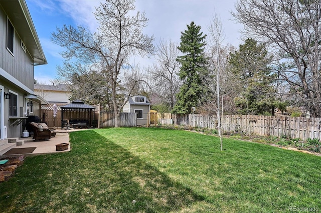 view of yard with a storage unit, a gazebo, an outdoor structure, a fenced backyard, and a patio