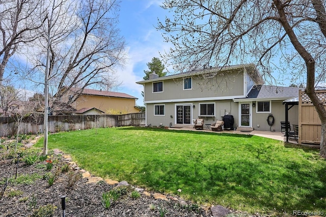 rear view of property with a patio, a fenced backyard, a yard, and a chimney