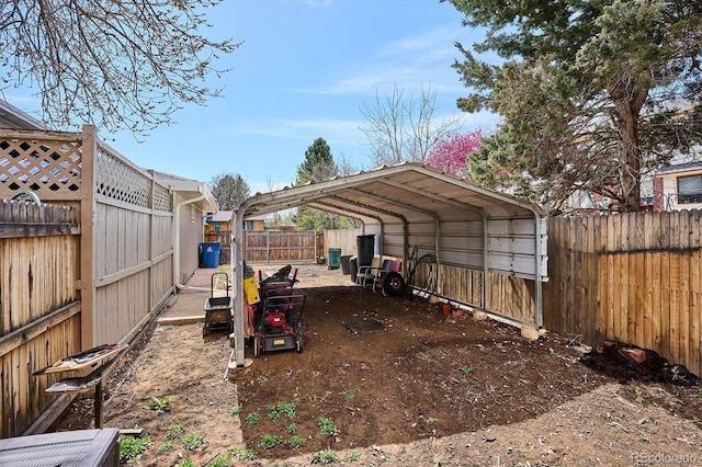 view of yard with a fenced backyard and a carport