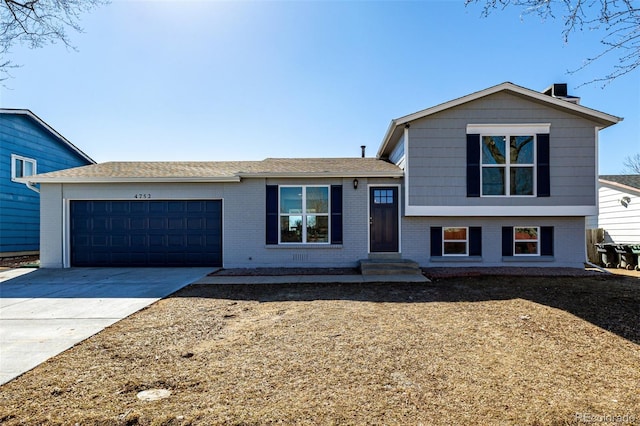 split level home featuring brick siding, driveway, and an attached garage