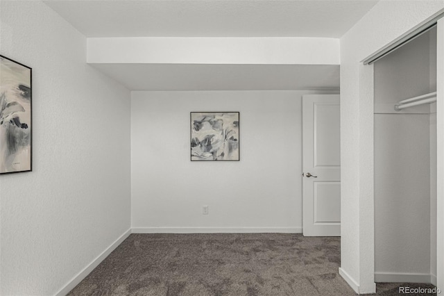 unfurnished bedroom featuring carpet floors, baseboards, and a closet