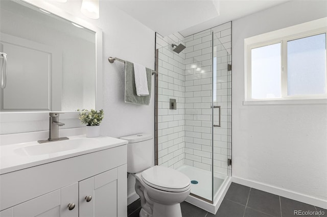 bathroom featuring toilet, a stall shower, baseboards, and vanity