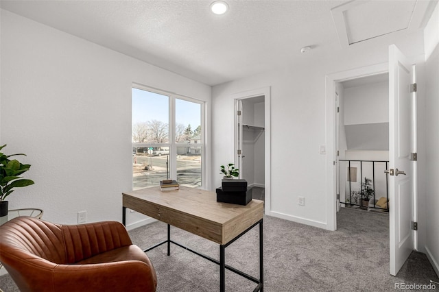 carpeted home office featuring baseboards and a textured ceiling