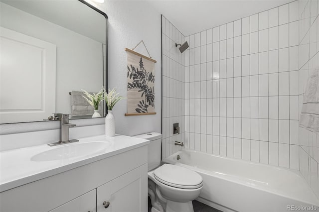 bathroom featuring toilet, shower / bathtub combination, a textured wall, and vanity