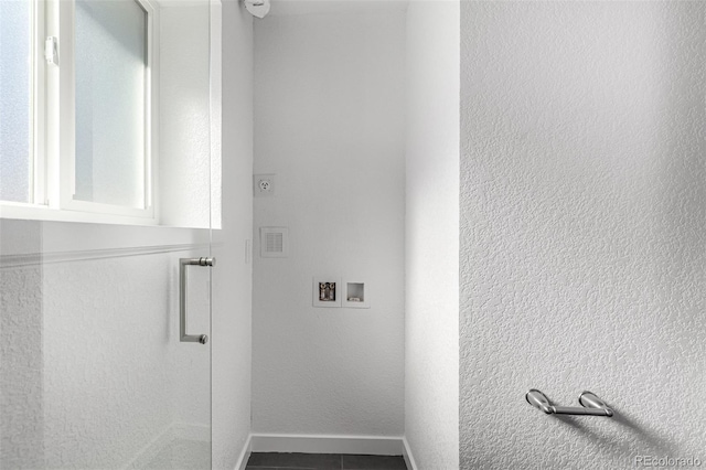 washroom featuring hookup for a washing machine, laundry area, a textured wall, and baseboards