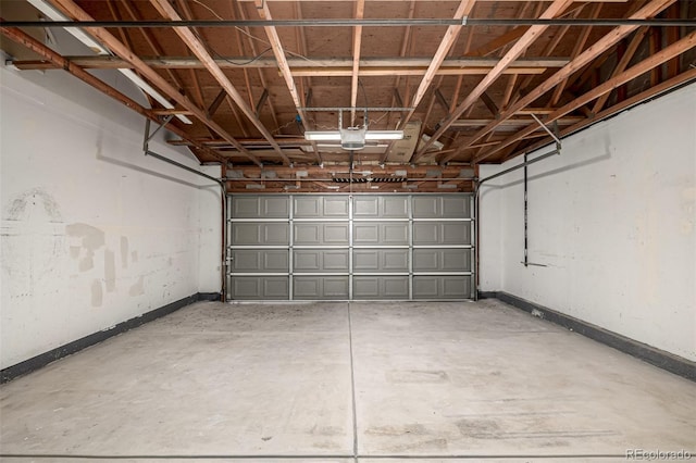 garage with a garage door opener and baseboards