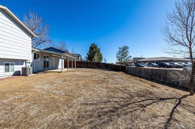 view of yard with a fenced backyard, a patio, and central air condition unit