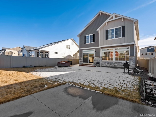 21901 E 42nd Pl, Aurora, CO 80019 - back of property featuring board and batten siding, a patio area, stone siding, and a fenced backyard