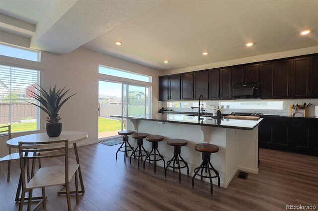 21901 E 42nd Pl, Aurora, CO 80019 - kitchen with black appliances, healthy amount of natural light, a breakfast bar, dark wood finished floors, and recessed lighting