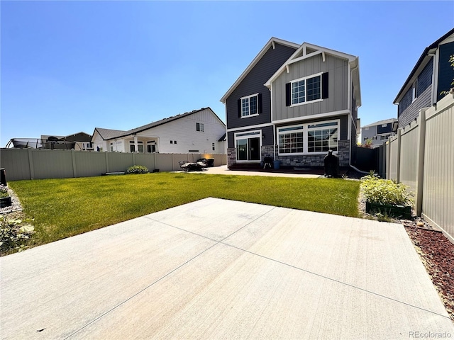 21901 E 42nd Pl, Aurora, CO 80019 - back of property with board and batten siding, stone siding, a patio area, and a fenced backyard