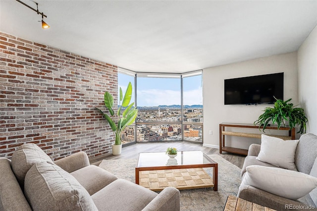 1625 Larimer St Unit 2501, Denver, CO 80202 - living area with a wall of windows, wood finished floors, brick wall, and baseboards