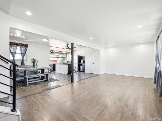 living room featuring wood finished floors, a healthy amount of sunlight, and baseboards