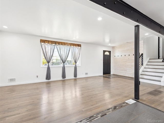 unfurnished living room featuring baseboards, wood finished floors, visible vents, and recessed lighting