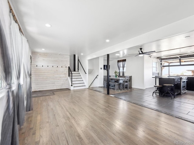 living room featuring stairway, a ceiling fan, wood finished floors, baseboards, and recessed lighting