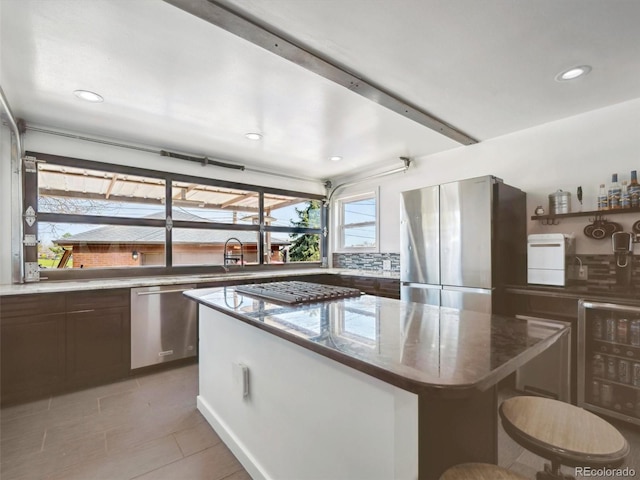 kitchen featuring stainless steel appliances, a center island, a sink, light tile patterned flooring, and recessed lighting