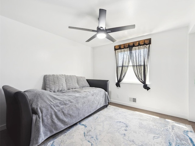 bedroom with visible vents, wood finished floors, baseboards, and a ceiling fan