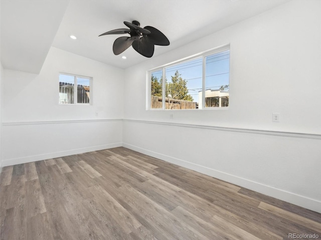 spare room with wood finished floors, baseboards, and a healthy amount of sunlight