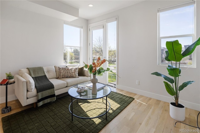 living room with baseboards, plenty of natural light, wood finished floors, and recessed lighting
