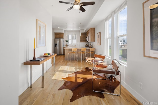 living area with light wood-style floors, baseboards, and recessed lighting