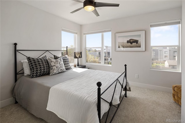 carpeted bedroom featuring baseboards and a ceiling fan