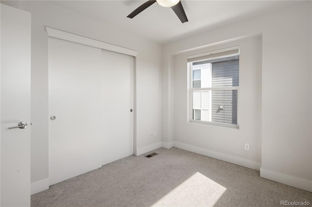 unfurnished bedroom featuring carpet, a closet, ceiling fan, and baseboards