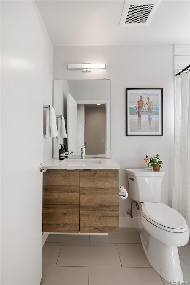 bathroom with toilet, tile patterned flooring, and vanity