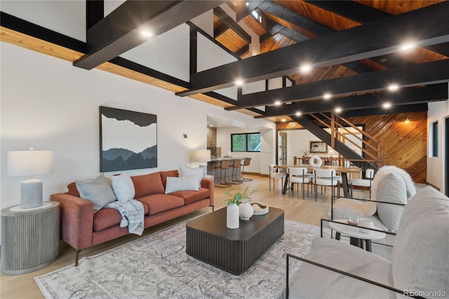 1298 Meadow View Dr, Evergreen, CO 80439 - living area with stairway, light wood finished floors, beam ceiling, wooden walls, and high vaulted ceiling