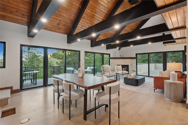 1298 Meadow View Dr, Evergreen, CO 80439 - dining area with a wood ceiling with exposed beams, a fireplace, light wood-type flooring, healthy amount of natural light, and high vaulted ceiling