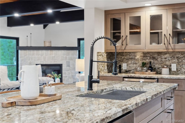 1298 Meadow View Dr, Evergreen, CO 80439 - kitchen with light stone counters, tasteful backsplash, glass insert cabinets, and a fireplace